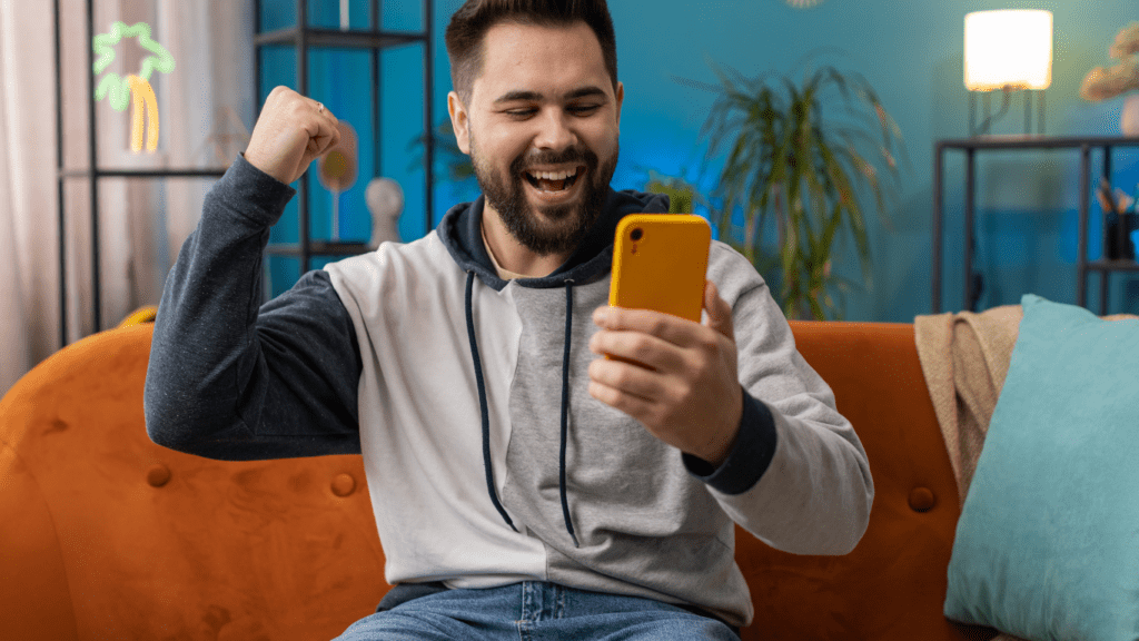 A surprised person looking at their phone while sitting on a couch