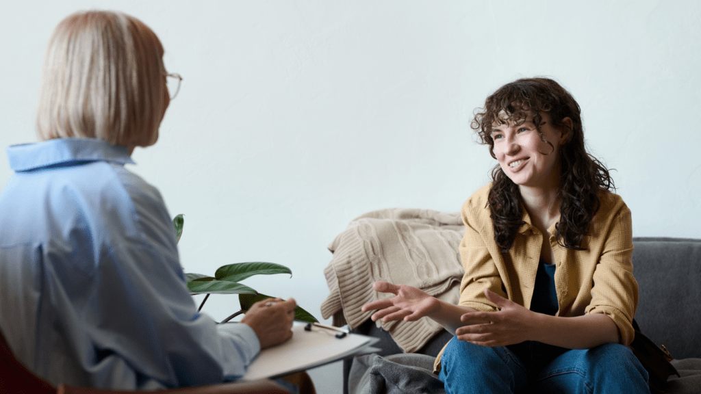 a person sitting on a couch talking to another person