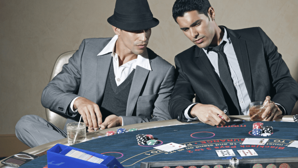 two individuals in suits playing blackjack at a casino table