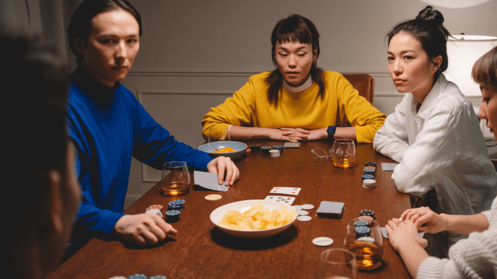 a group of people sitting around a table playing poker