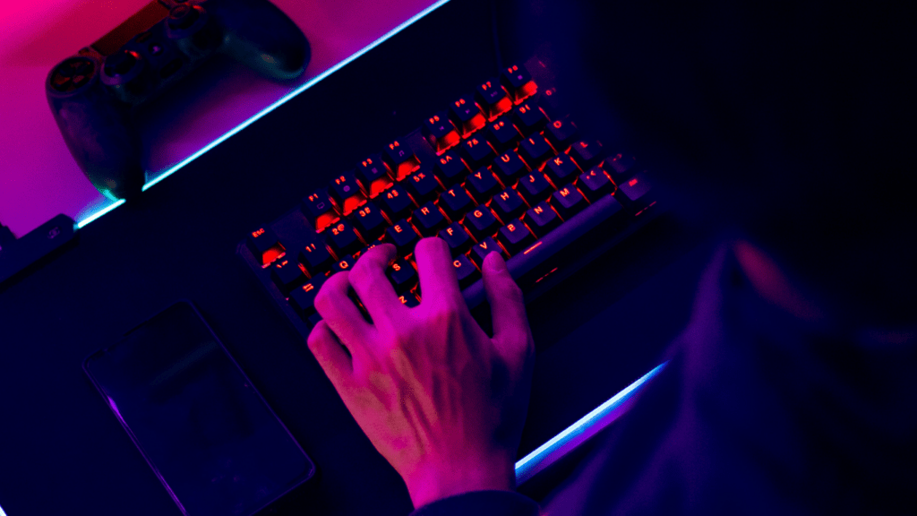 a person is typing on a keyboard in a dark room