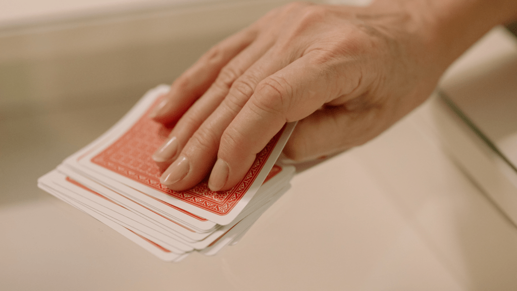 a person holding up a deck of playing cards