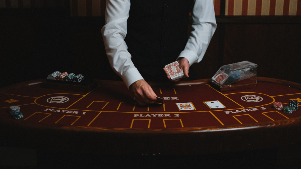 a person in a suit and tie playing cards at a casino table