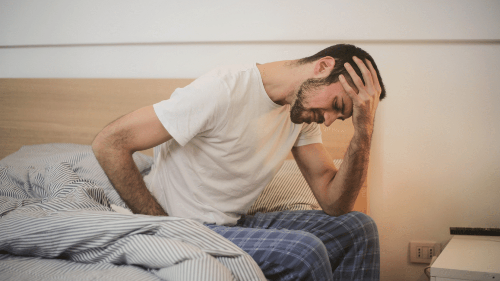 a person in a white shirt is holding their head in their hands