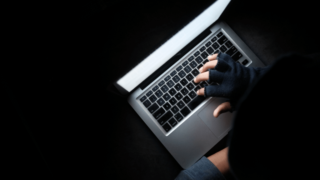 a person typing on a laptop computer in the dark