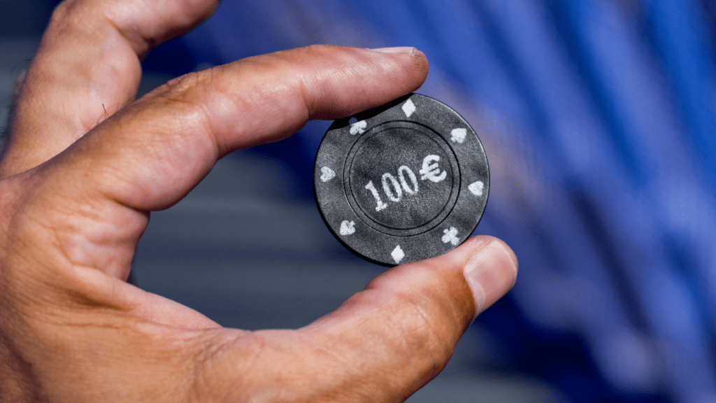 close-up of a person holding a poker chip