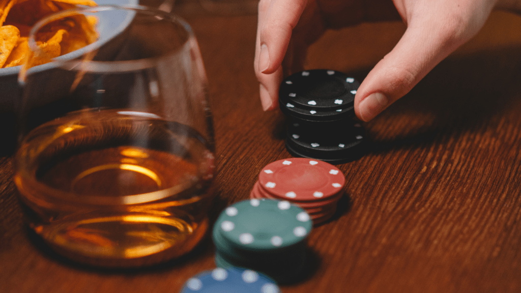 hands are holding a poker chip on a table